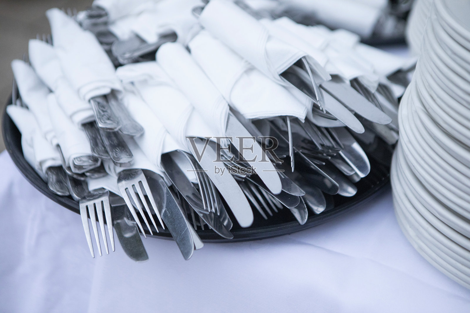 自助餐桌上用餐巾包裹的刀叉堆叠在一起照片摄影图片