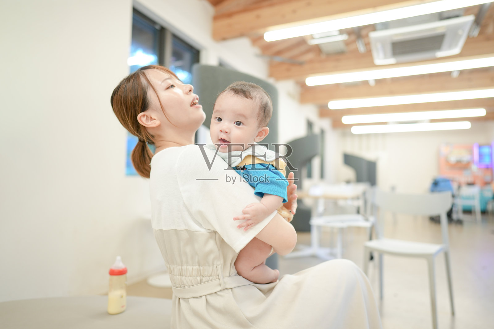 一位女性在一个有很多椅子的房间里抱着一个婴儿照片摄影图片