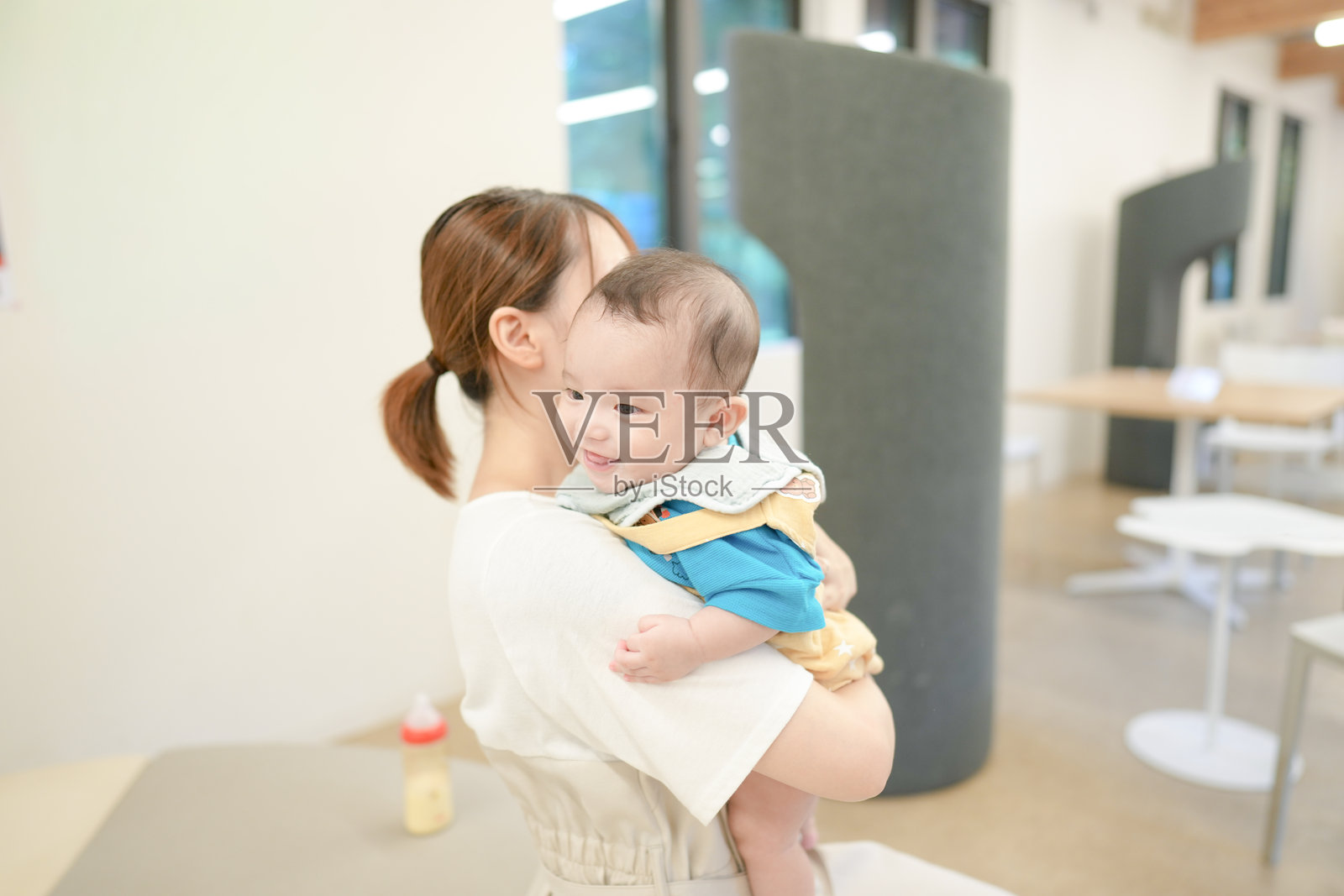 一位女性抱着婴儿。照片摄影图片