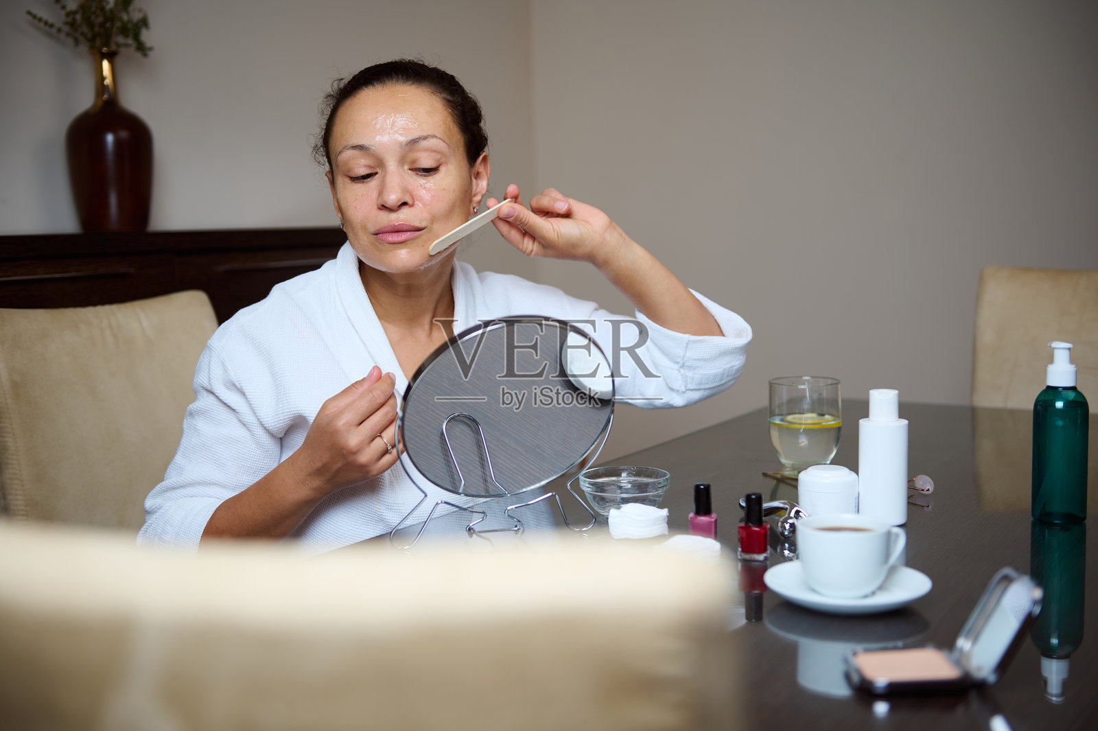 女性在家中享受面部护理，使用美容产品照片摄影图片