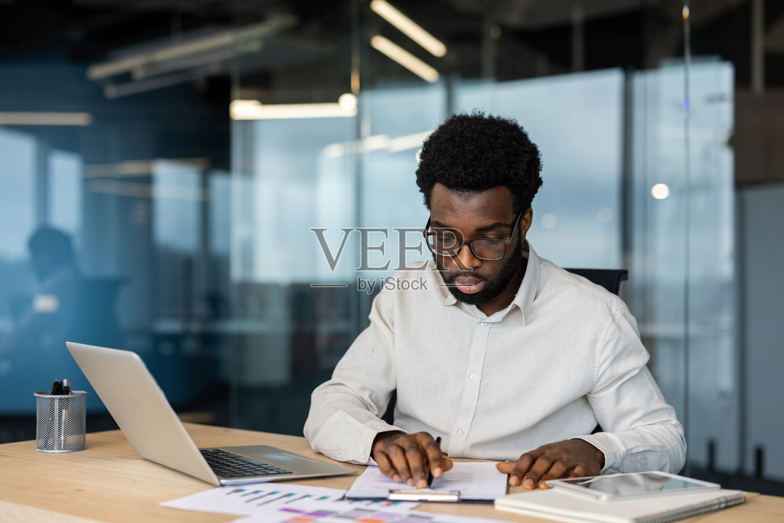 专注的商人在办公室桌子上处理文件。照片摄影图片