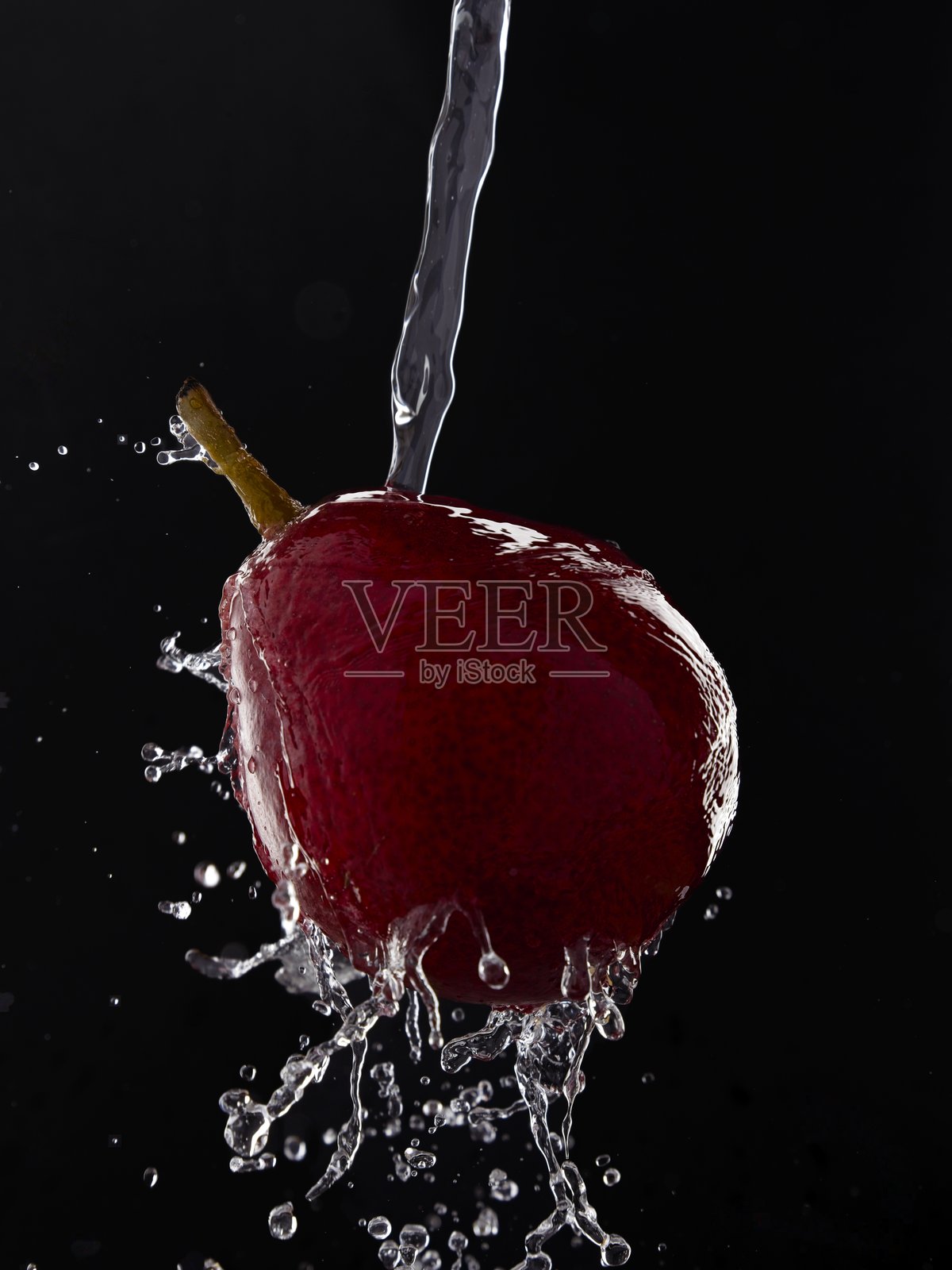 水花溅在红色梨子上。照片摄影图片