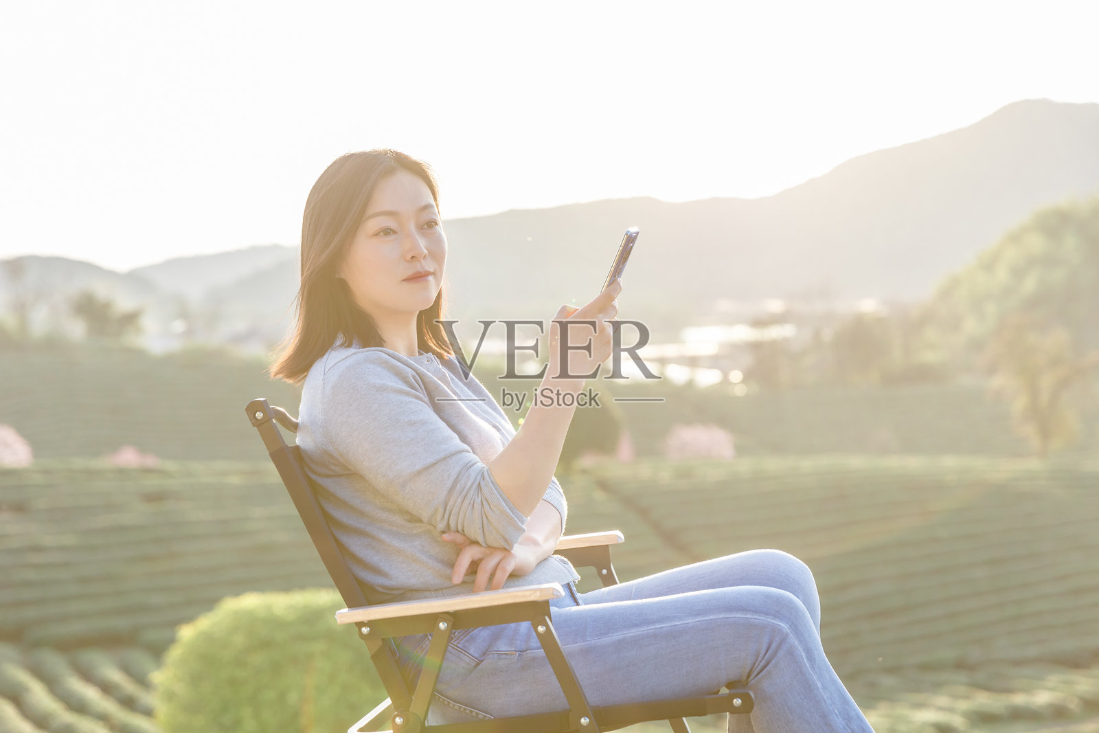 一位亚洲女性在乡村度假期间浏览手机信息照片摄影图片