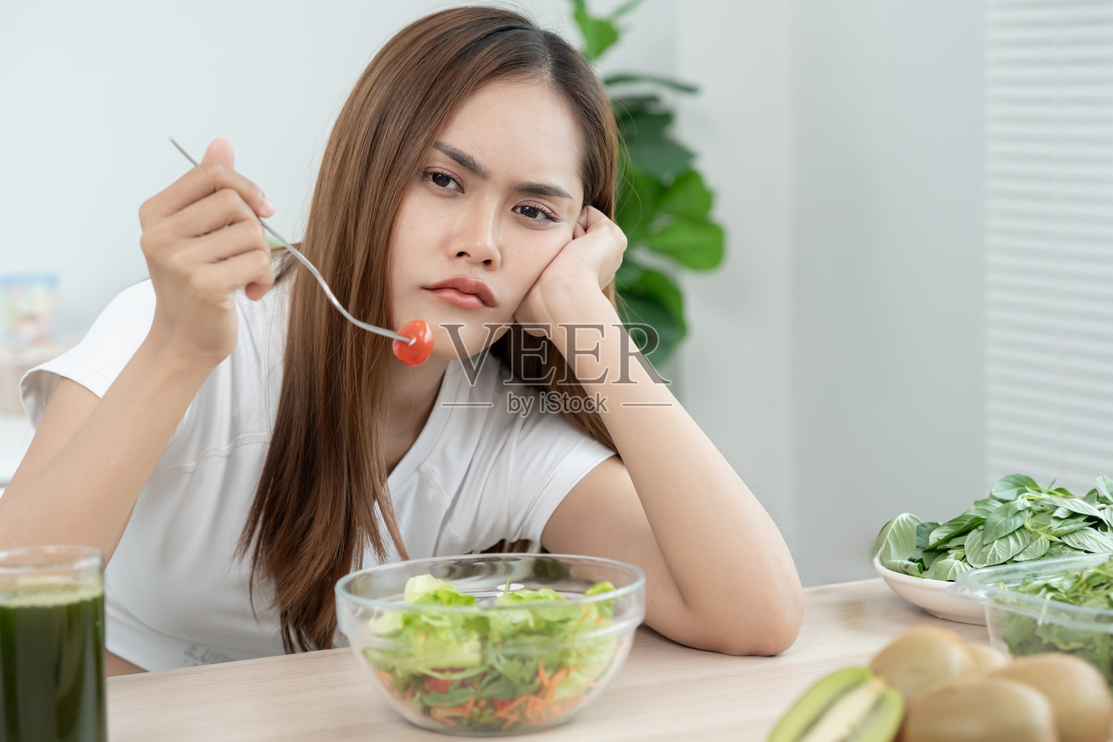 瘦身的亚洲女性对饮食食物感到非常无聊，正在选择低热量的饮食食物。健康的饮食，减肥，平衡，控制，减少脂肪，日常锻炼，塑造身材。照片摄影图片