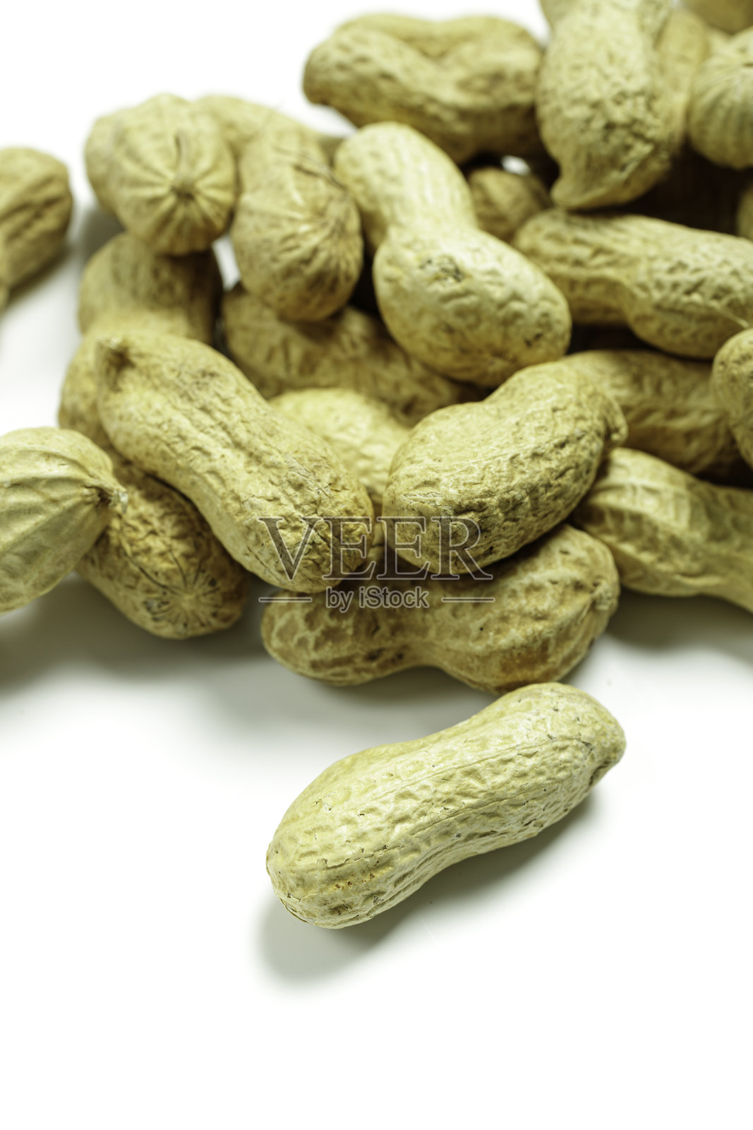 白色背景上的一堆完整的带壳花生照片摄影图片