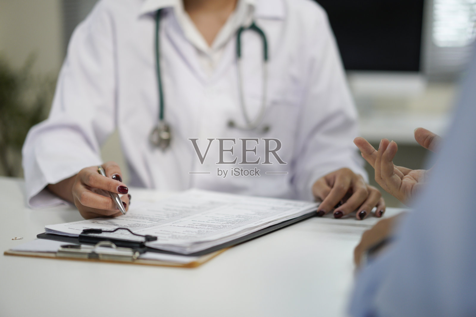 未知的医生和病人在医院办公室的桌子旁交谈，特写人手。医学与健康护理概念照片摄影图片