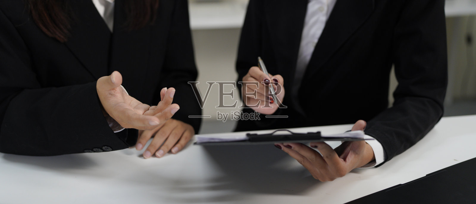 特写。两位商务人士在办公室交谈，计划分析投资和市场营销。商务会议中进行新项目的头脑风暴和数据文件分析。照片摄影图片