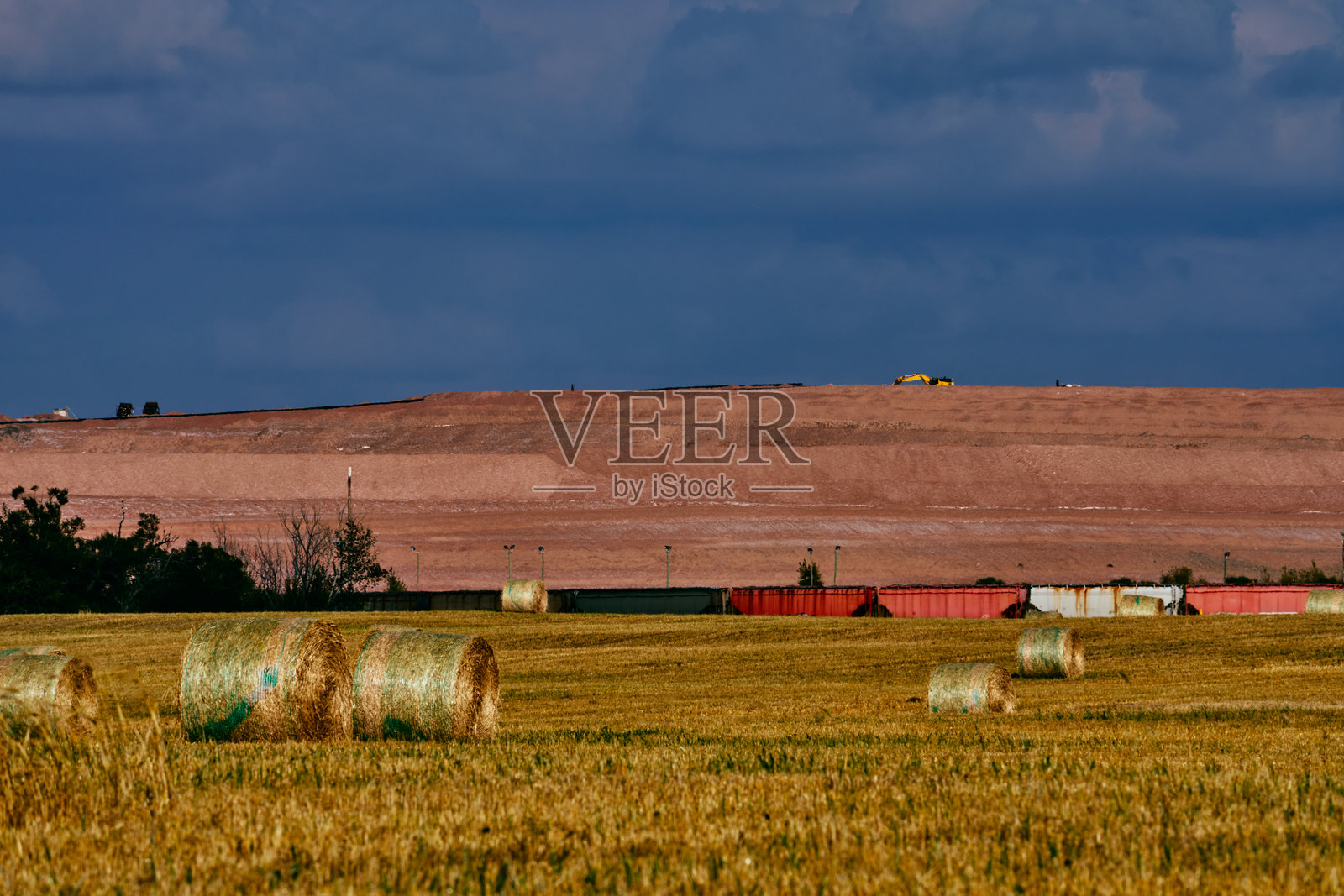 萨斯喀彻温省的农田上有干草堆、钾矿和货运列车照片摄影图片