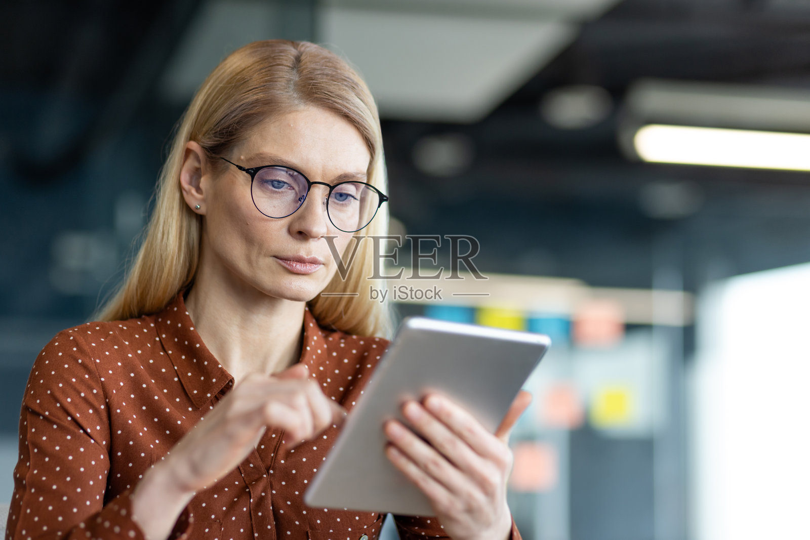 专业女性在现代办公室环境中使用平板电脑照片摄影图片