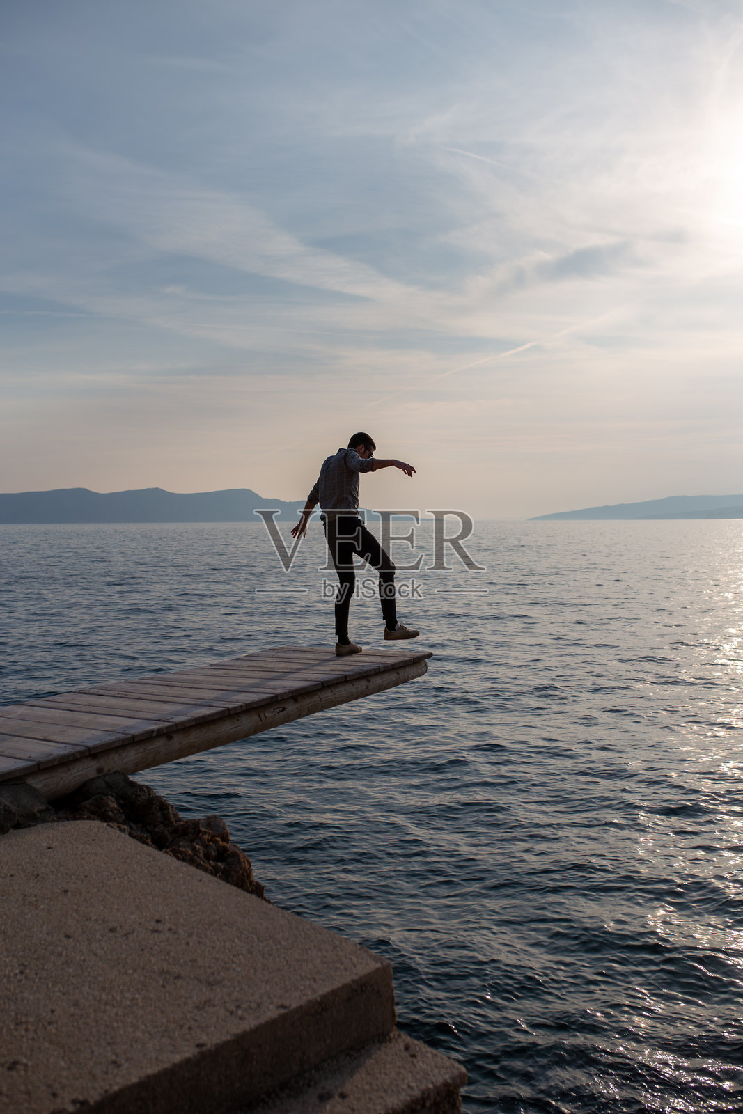 在海上跳水板上保持平衡照片摄影图片