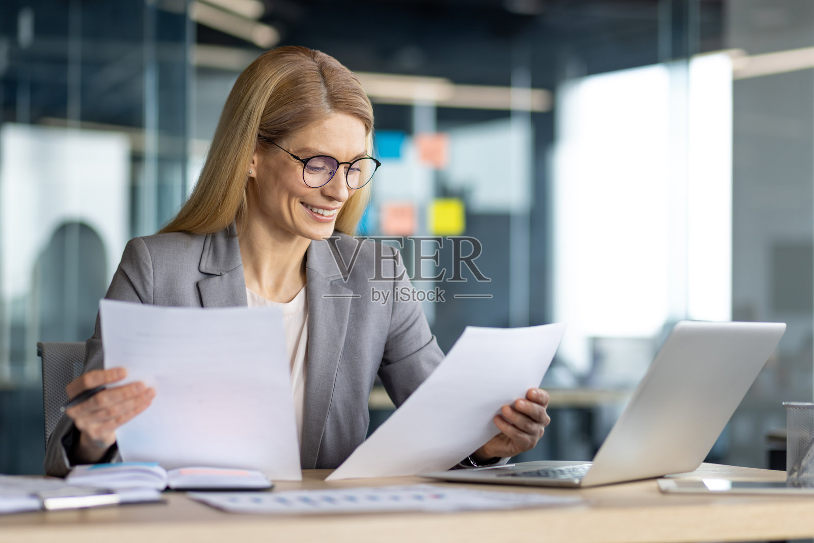 专业女性在现代办公室环境中分析文件照片摄影图片