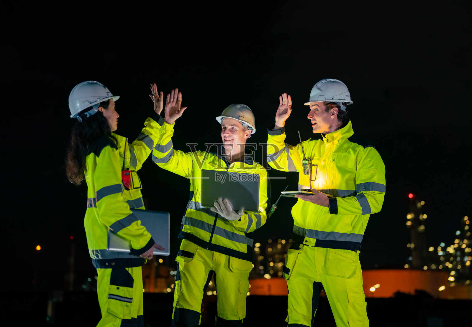 工程师团队在石油炼油厂建设工地上工作。照片摄影图片