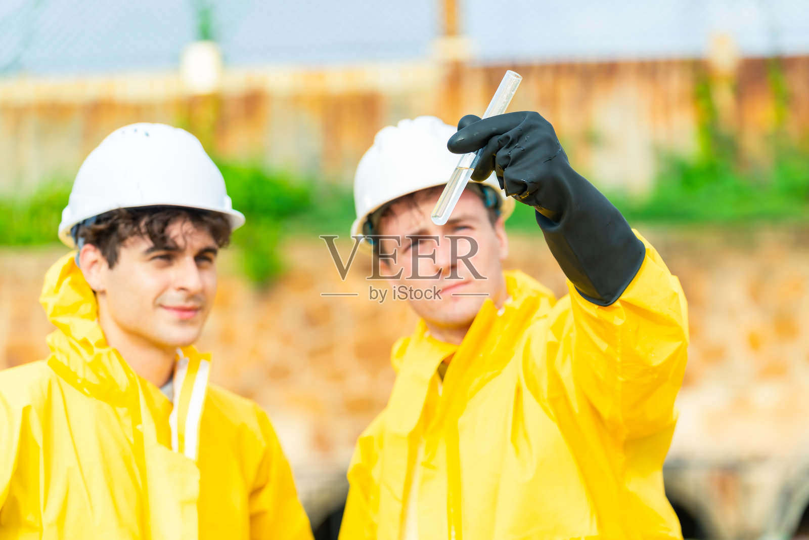 科学家在工业厂房附近采集水样。照片摄影图片