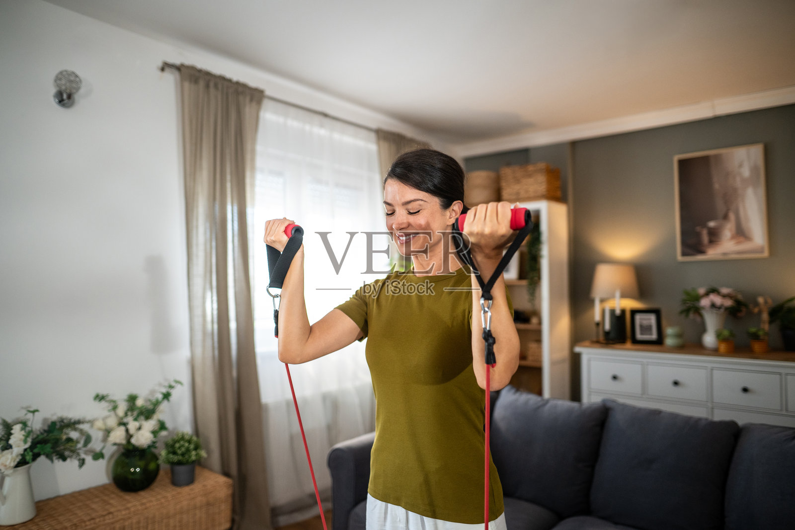 女性在家中锻炼时使用阻力带照片摄影图片