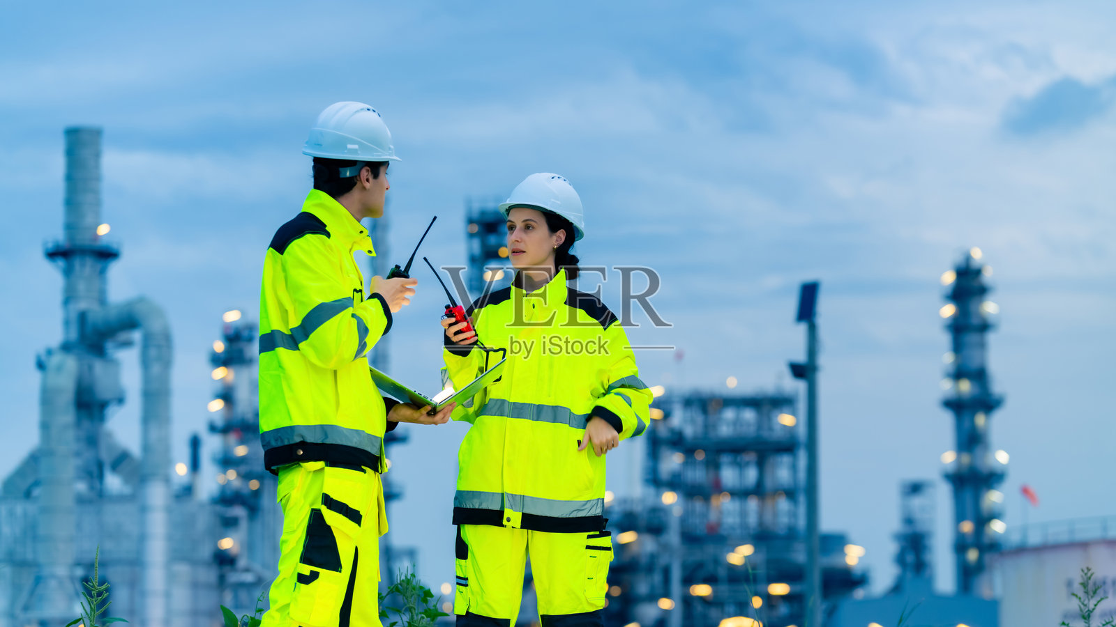 工程师团队在石油炼油厂建设工地上工作。照片摄影图片