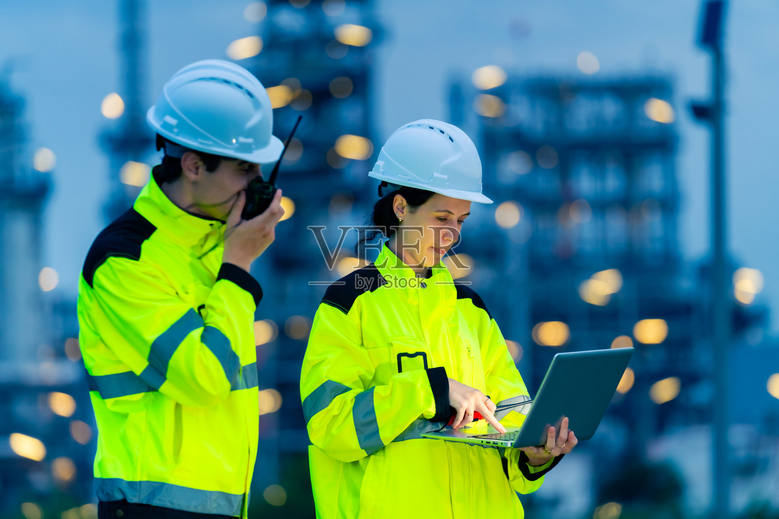 工程师团队在石油炼油厂建设工地上工作。照片摄影图片