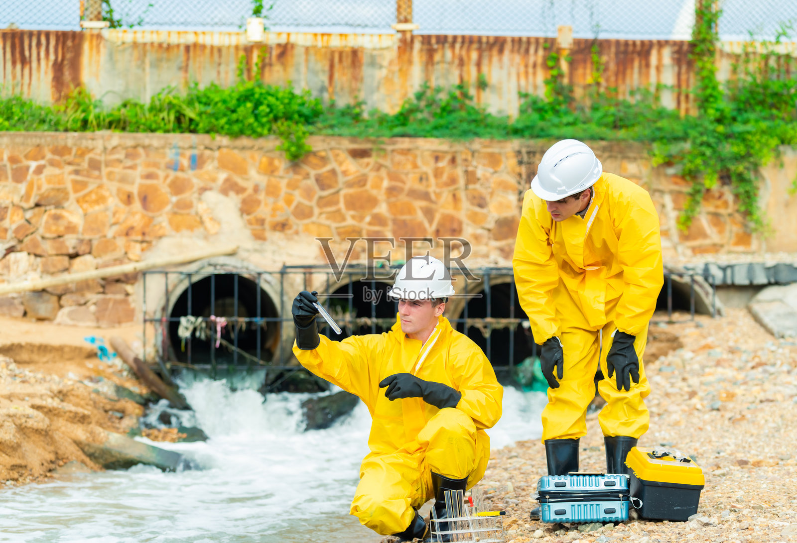 科学家在工业厂房附近采集水样。照片摄影图片