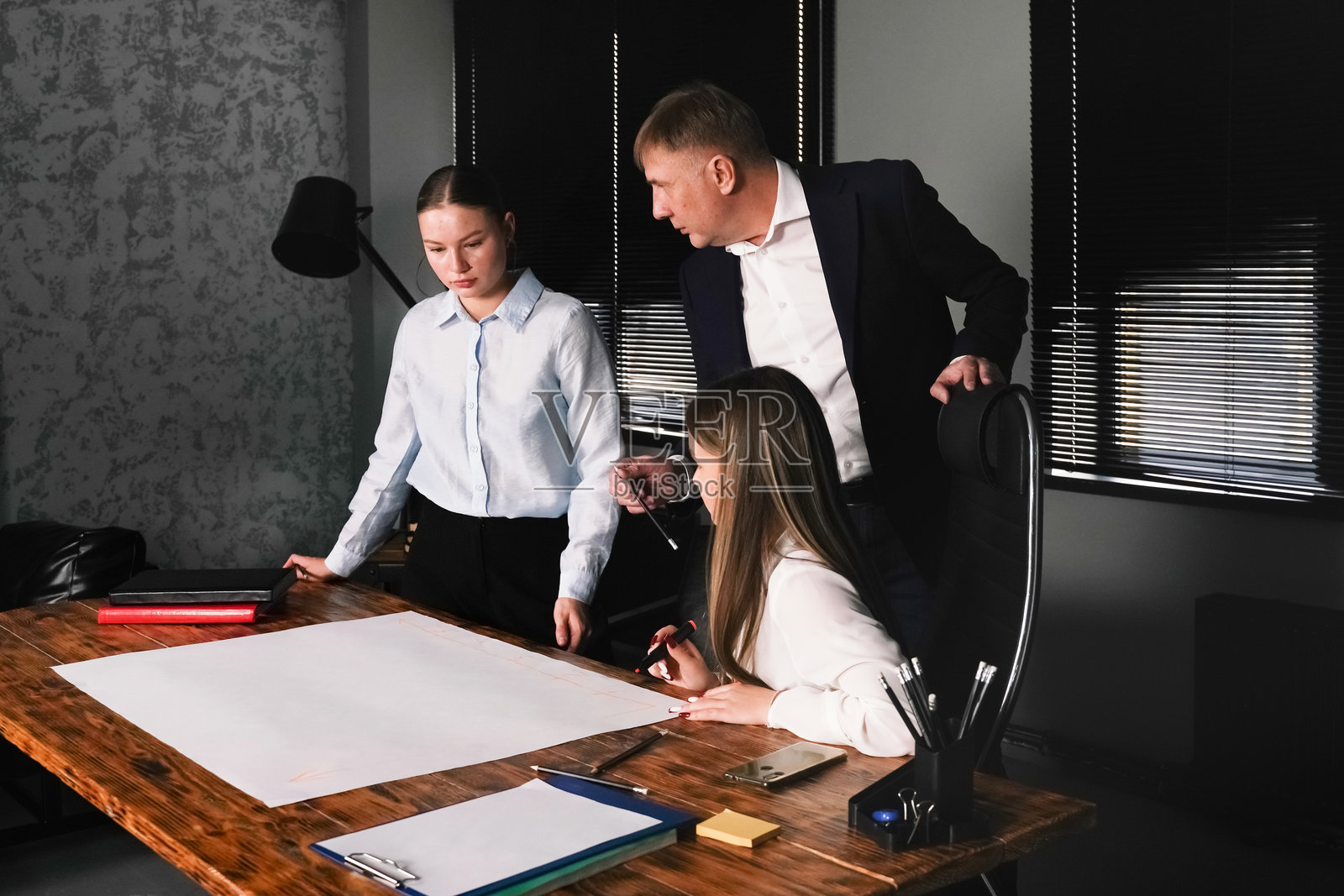 现代办公室中，两位女性和一位男性正在讨论项目创意的商务会议照片摄影图片