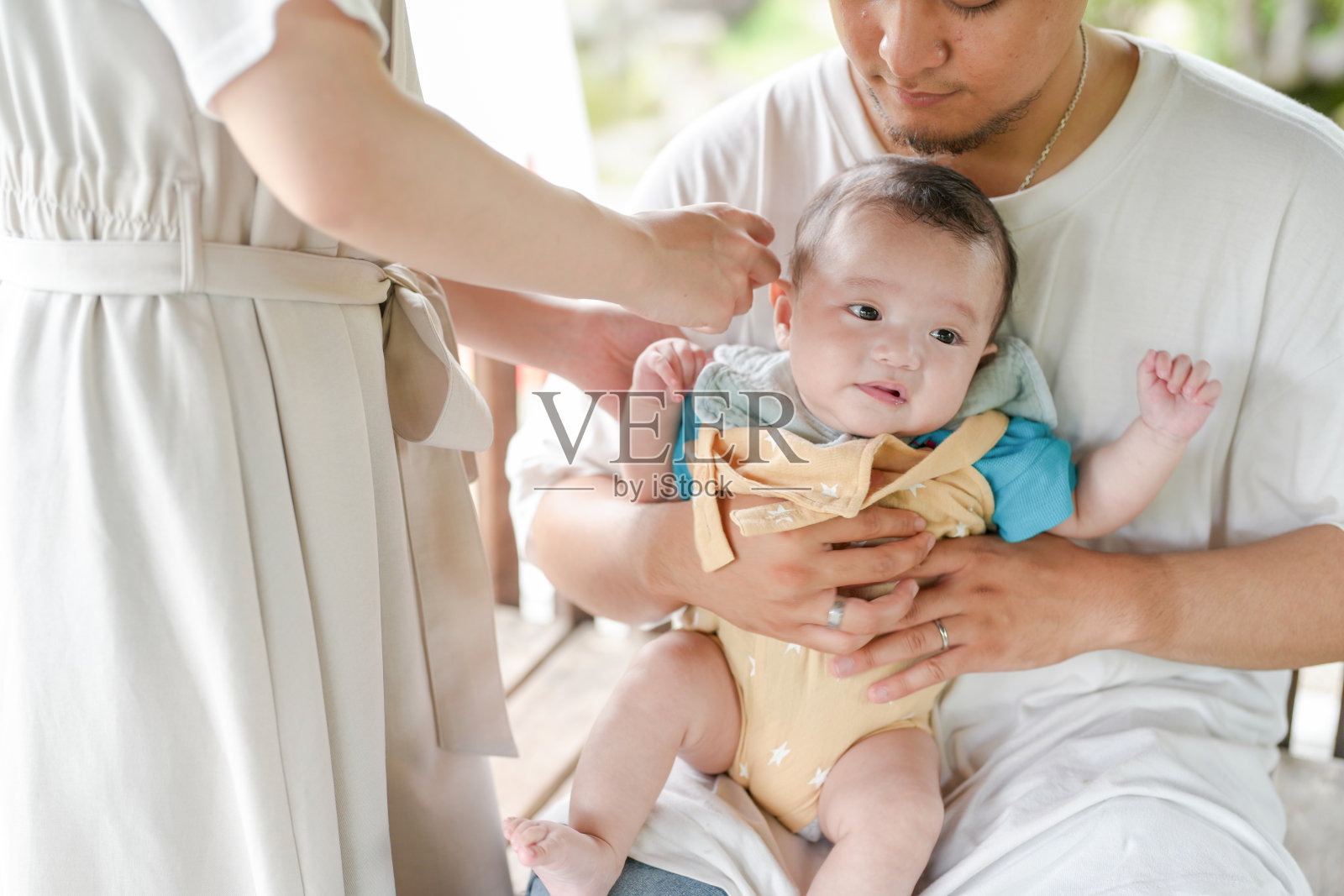 一男一女抱着一个婴儿照片摄影图片