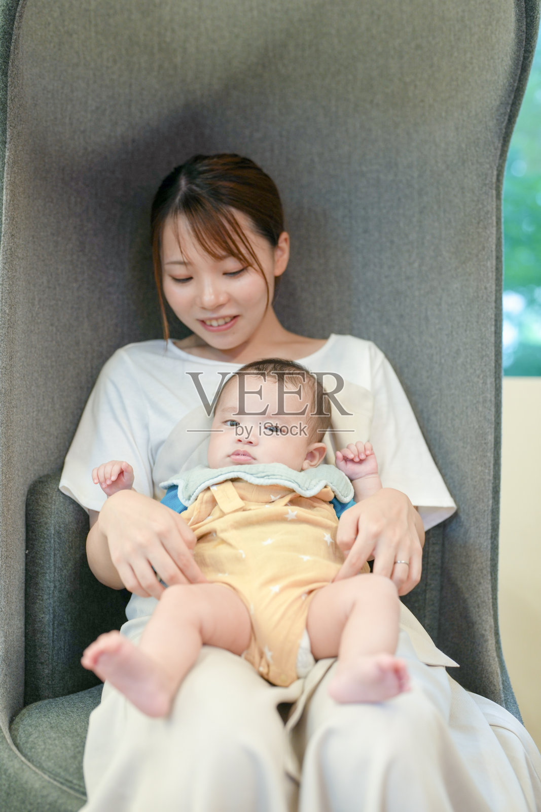 一位女性坐在椅子上抱着一个婴儿照片摄影图片