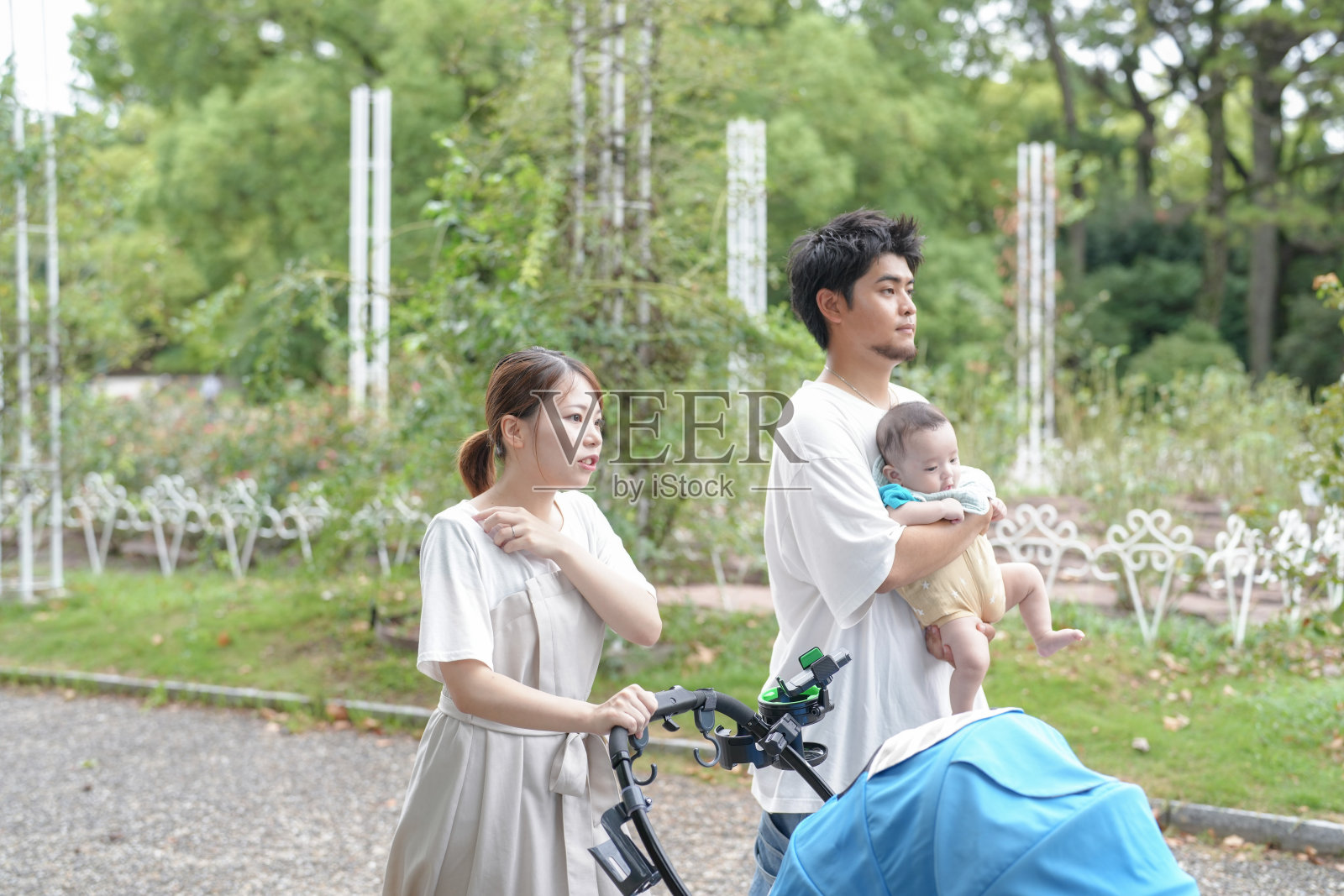 一男一女推着婴儿车散步照片摄影图片