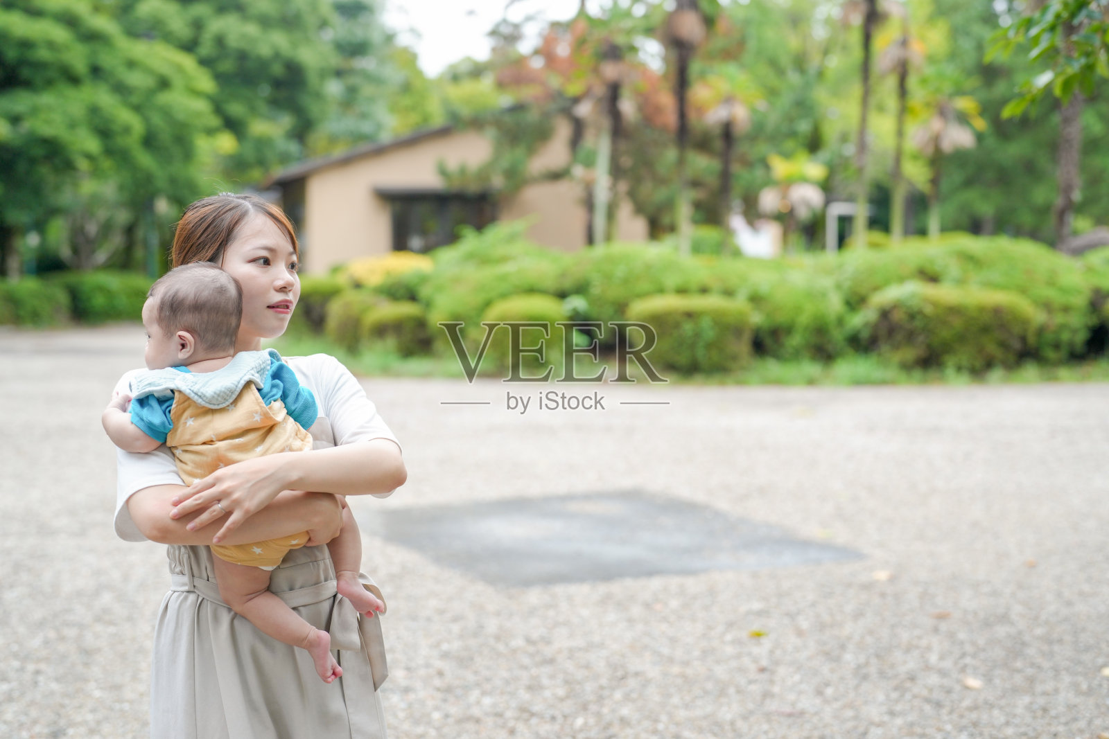 一位女性在公园里抱着一个婴儿照片摄影图片