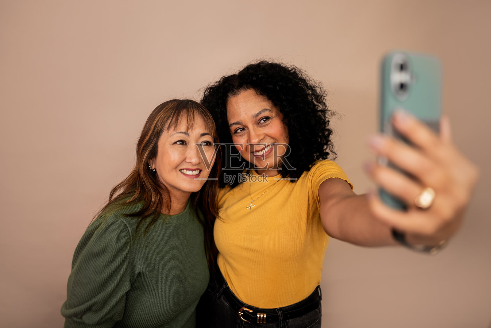 成熟的朋友们在摄影棚里用手机自拍照片摄影图片