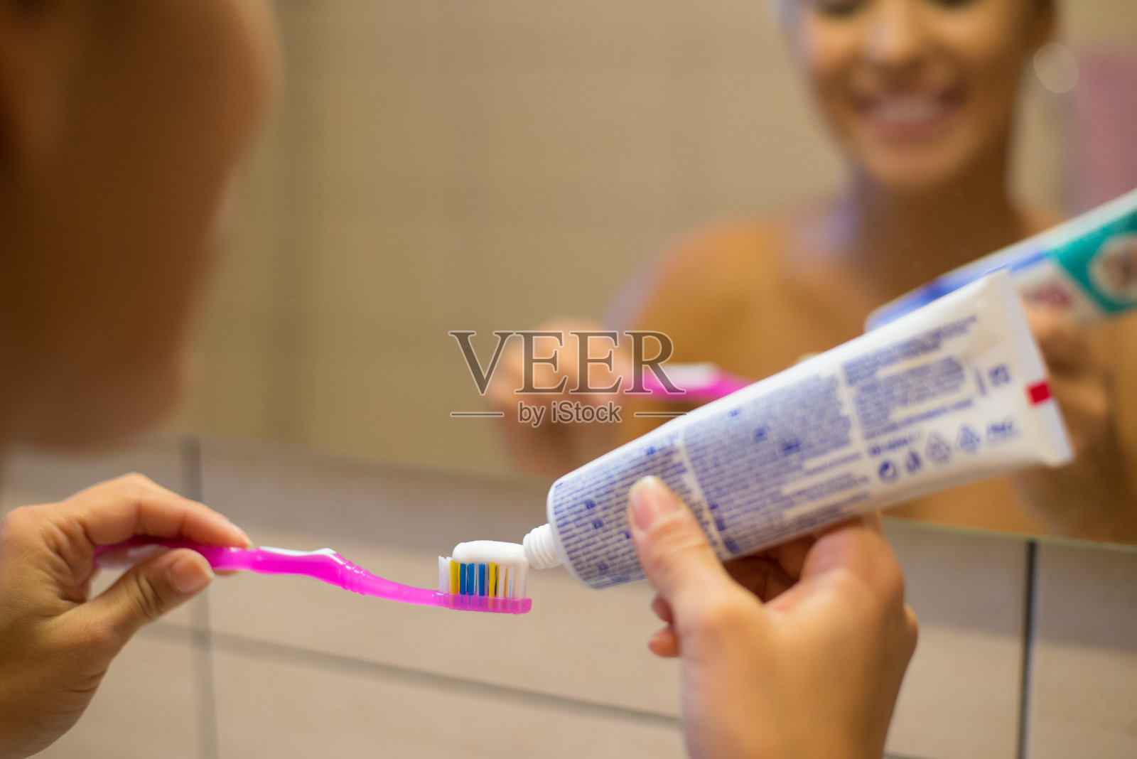 年轻微笑的女性在浴室刷牙照片摄影图片