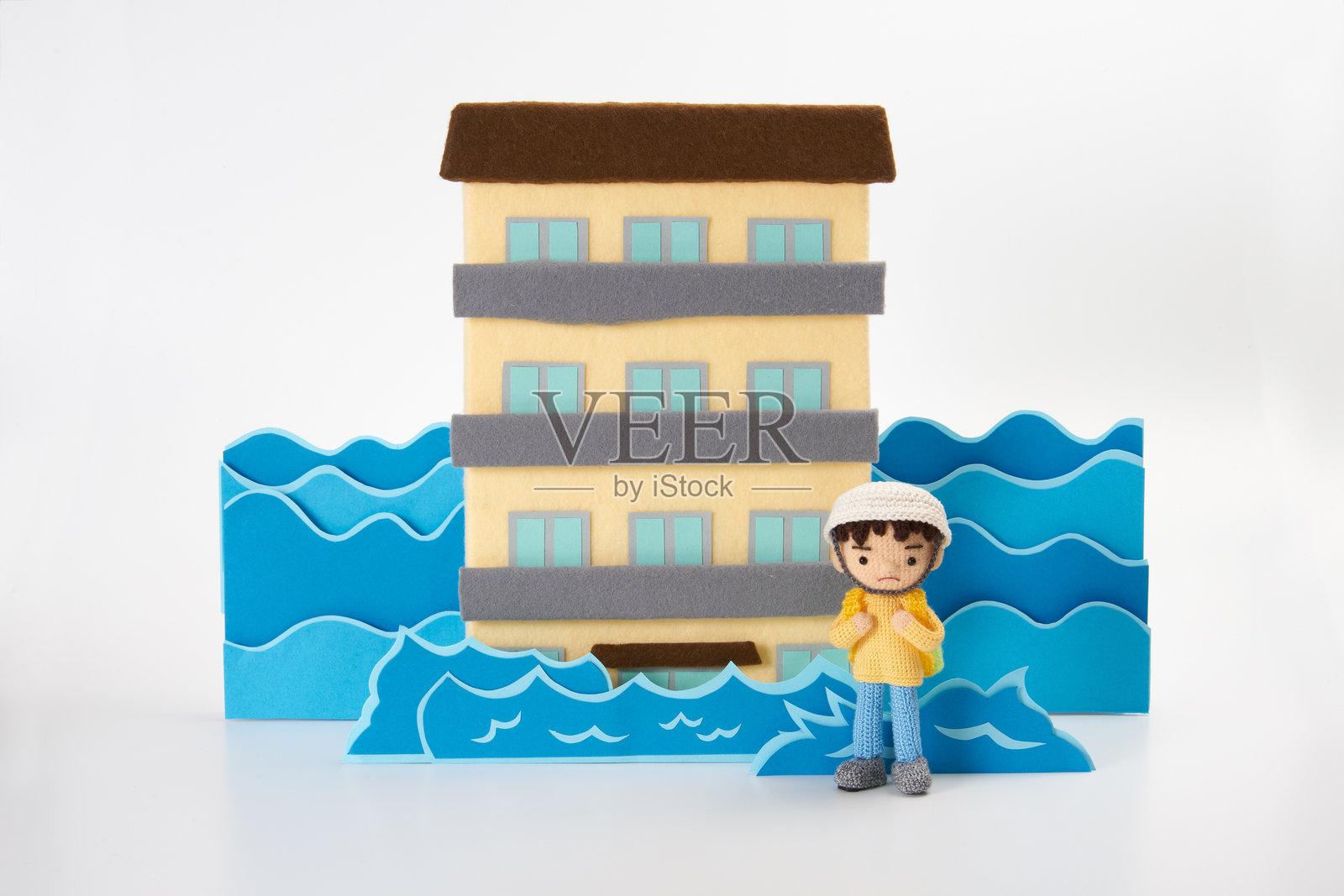 白色背景上的小巧可爱的毛线玩偶。自然灾害与撤离。照片摄影图片