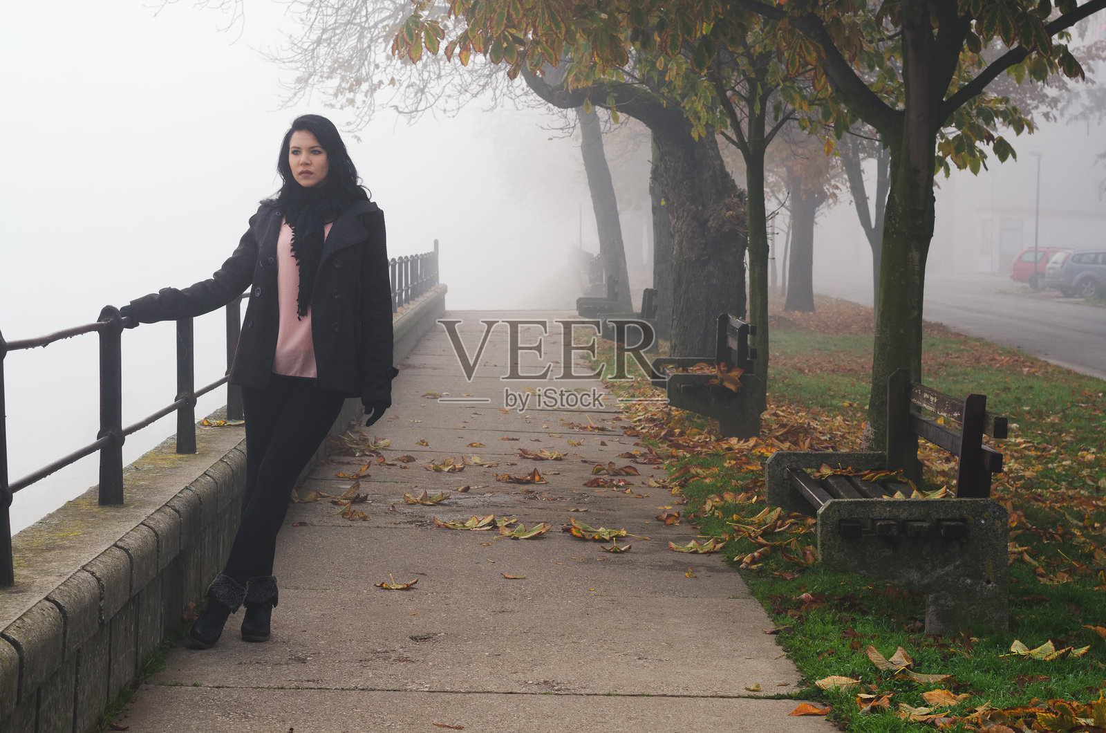 美丽的年轻女性在雾蒙蒙的秋天户外散步照片摄影图片