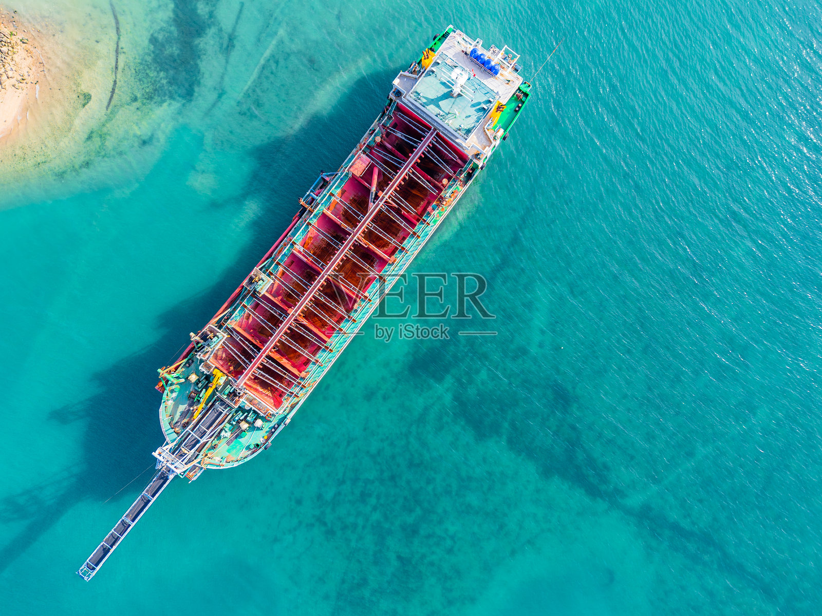 大型货船停靠在清澈的碧绿色海水中的鸟瞰图照片摄影图片