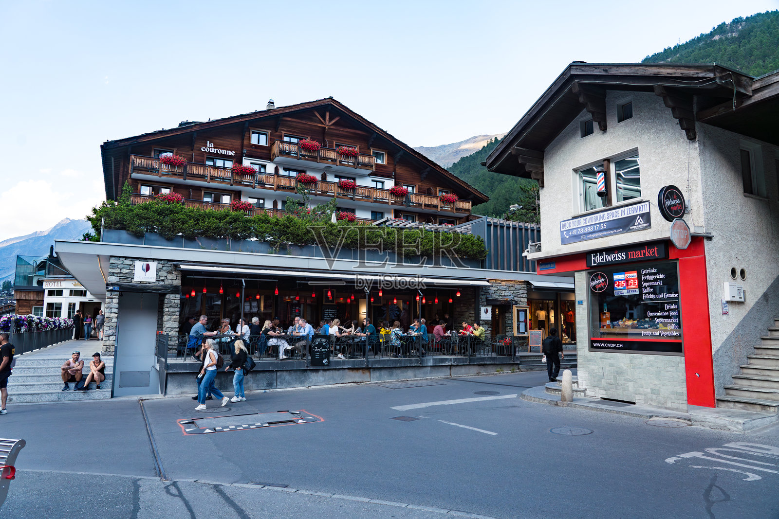 采尔马特市中心的傍晚景象，街道两旁有游客、餐馆和商店。照片摄影图片