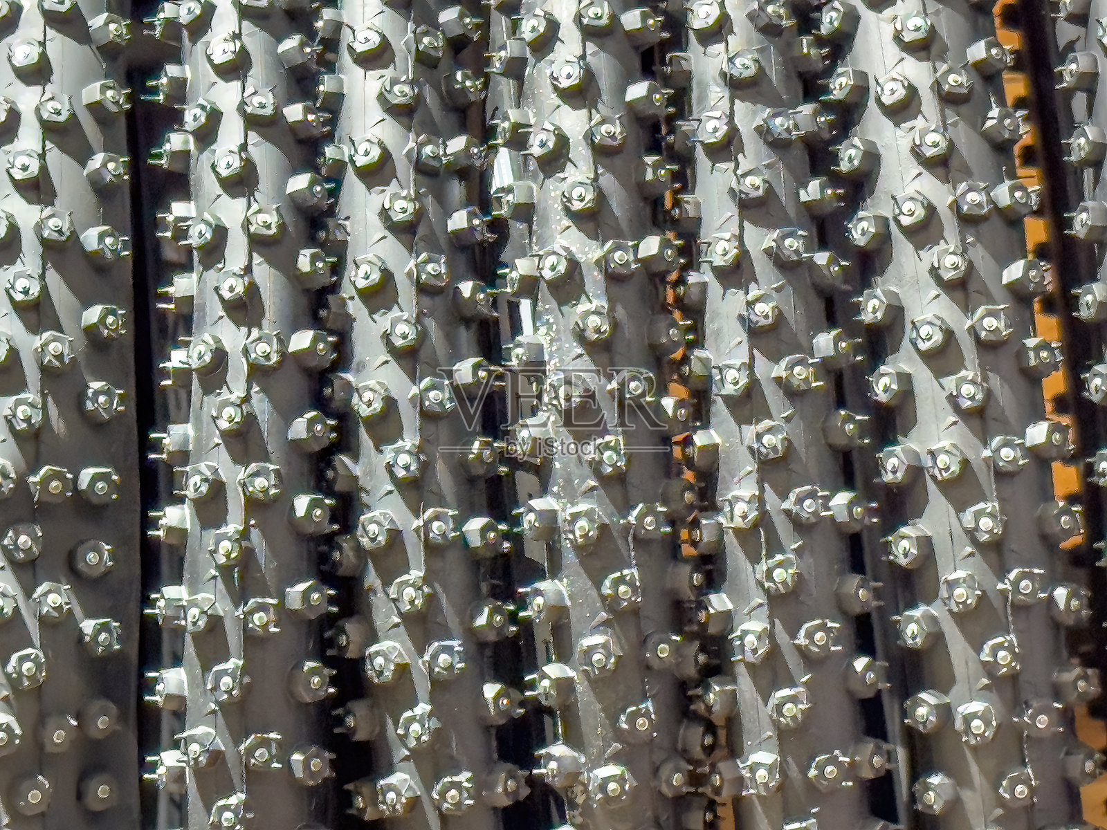 冬季轮胎上的轮胎钉排成行，特写镜头高对比度地突显了它们的金属质感。照片摄影图片