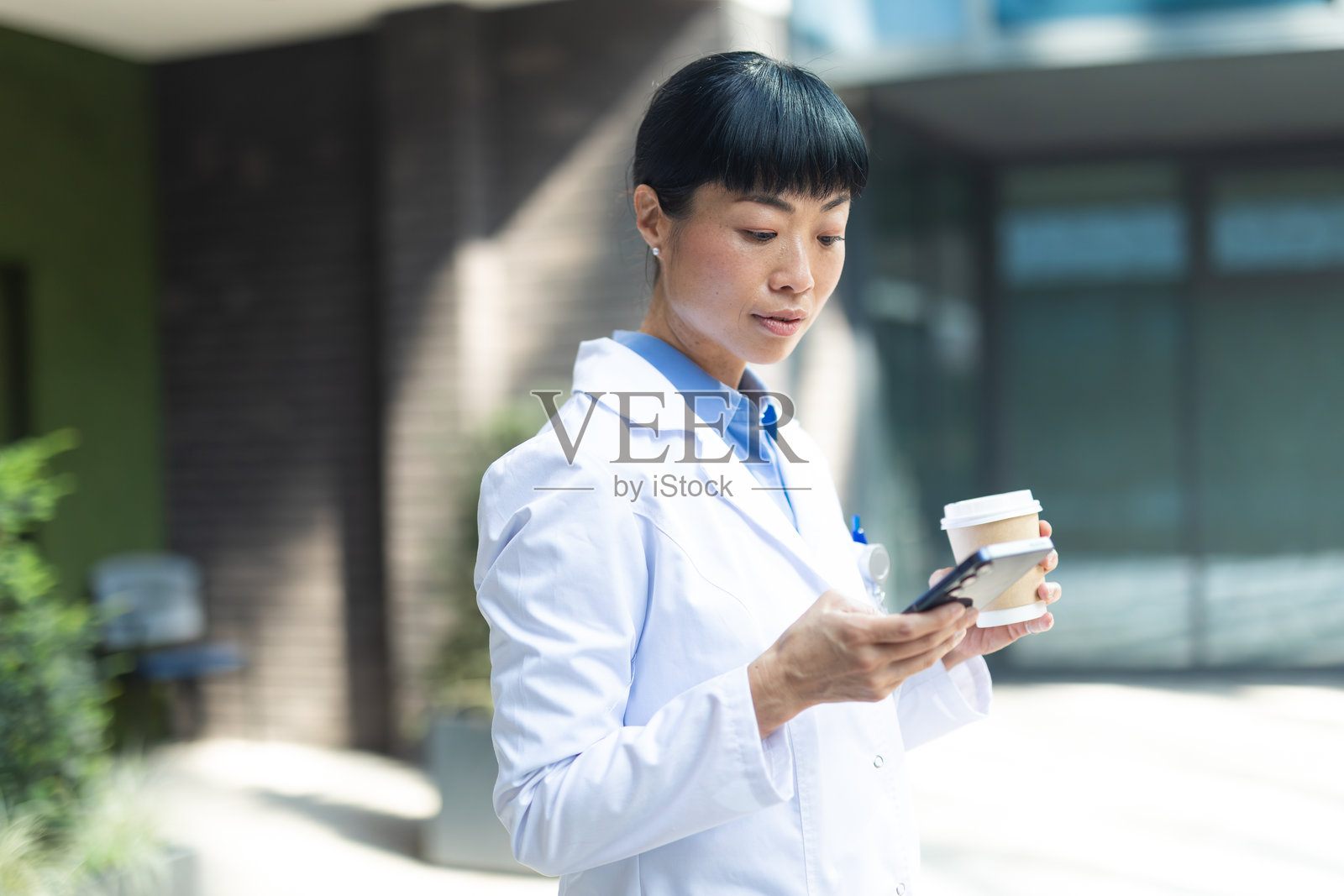 女医生在喝咖啡休息时使用智能手机照片摄影图片