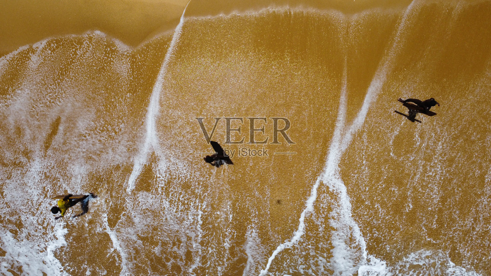 海岸上金色沙滩上冲浪者骑浪的鸟瞰图照片摄影图片