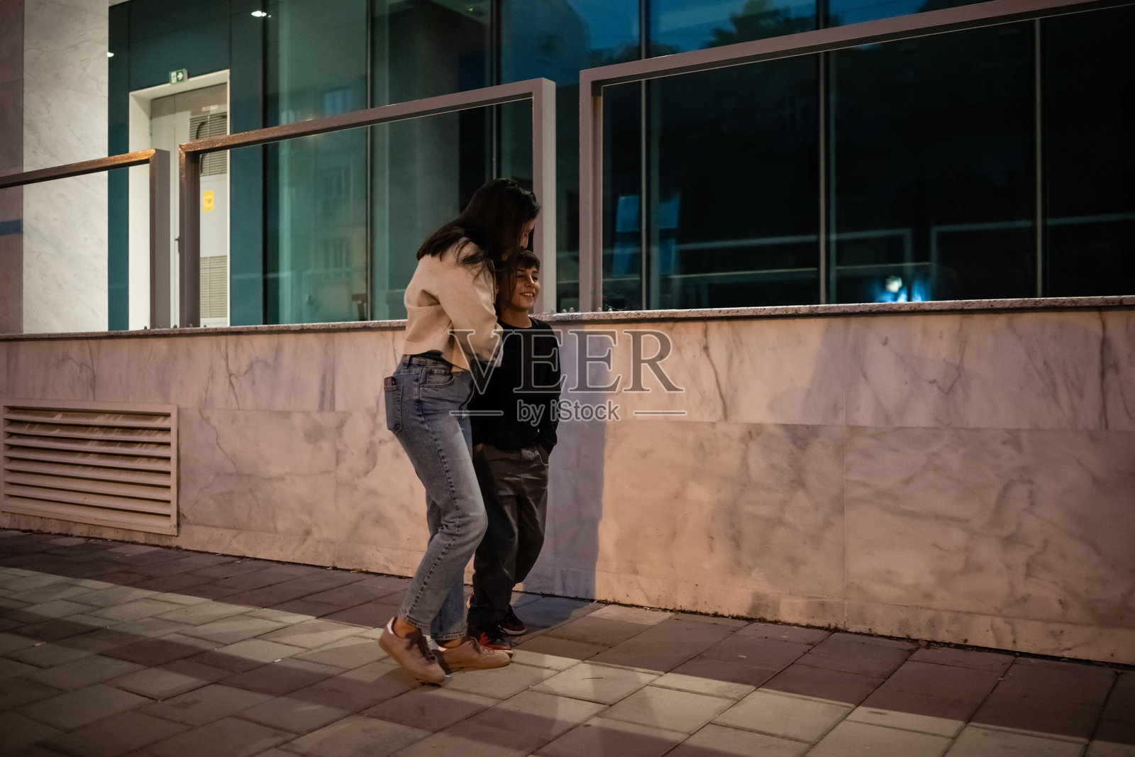 兄弟姐妹在城市夜街上散步聊天照片摄影图片