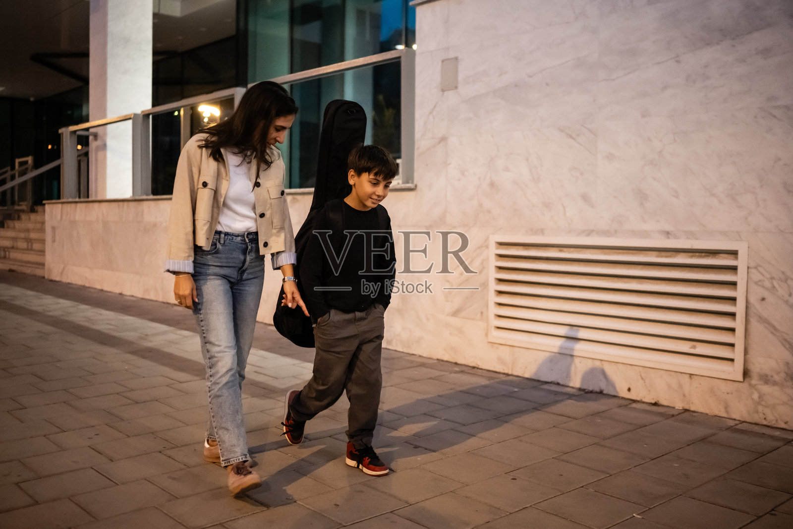 母亲和儿子在音乐课后一起走回家照片摄影图片