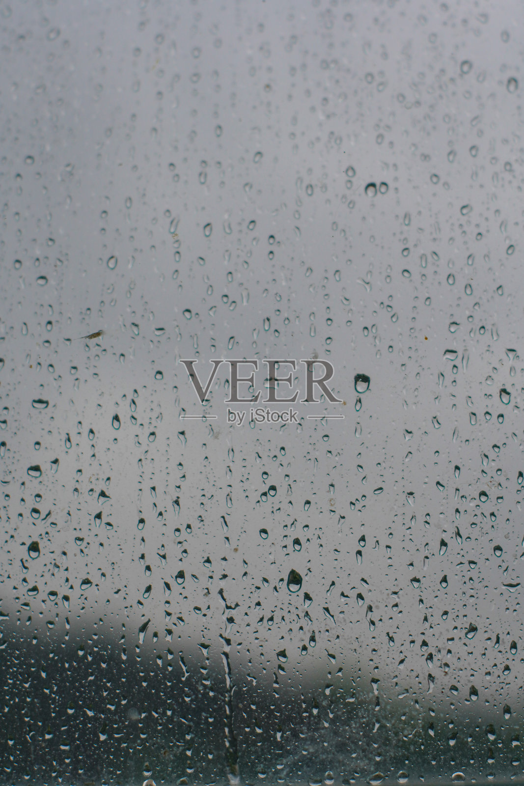 一扇窗户玻璃上覆盖着不同大小雨滴的特写镜头照片摄影图片