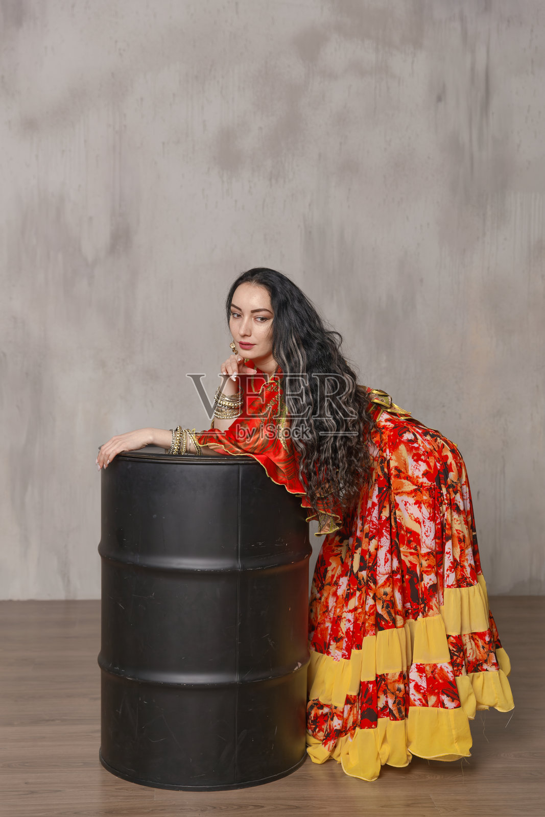 一位美丽的吉普赛女人穿着华丽的鲜红色民族服装，饰有金色装饰。照片摄影图片