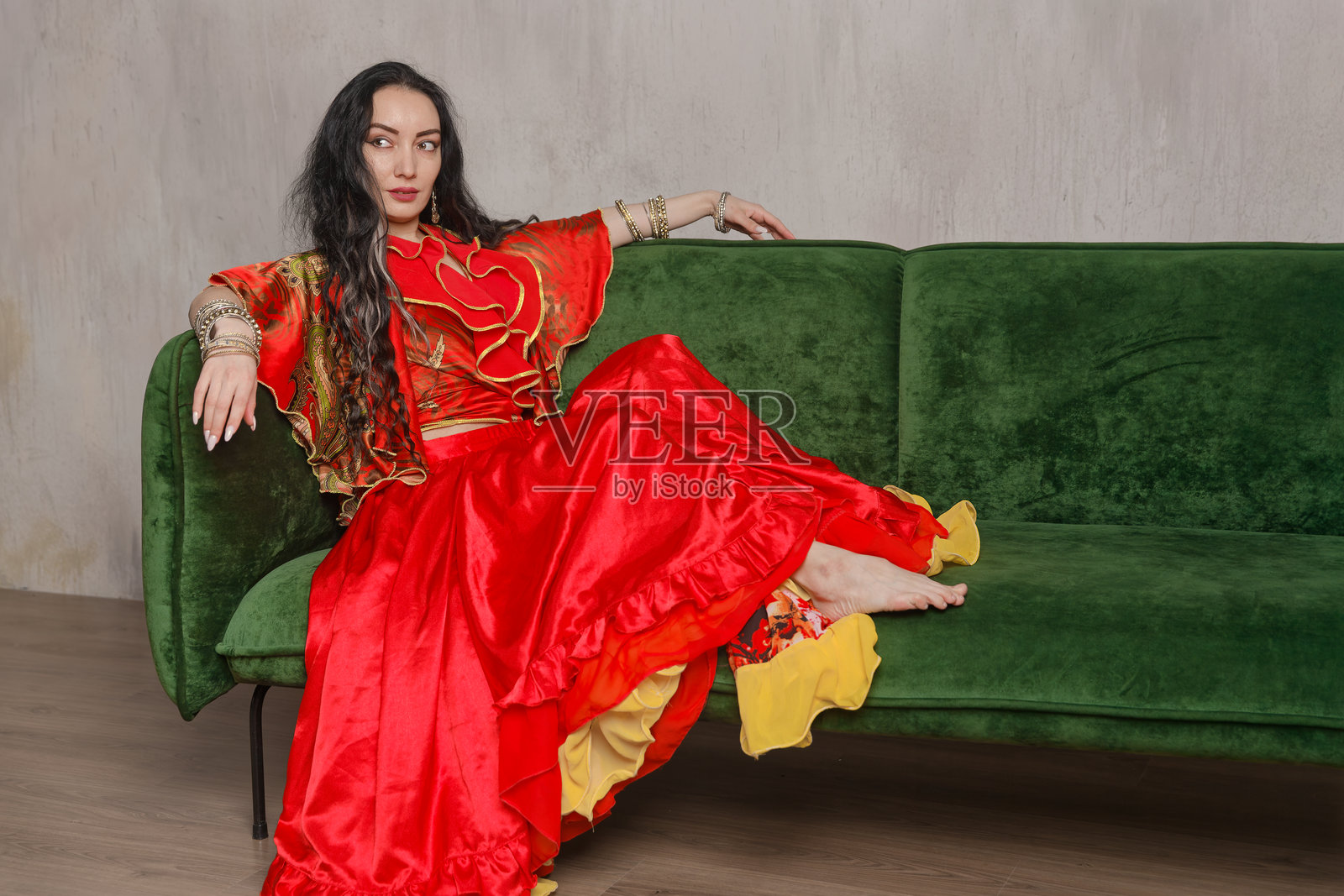 一位美丽的吉普赛女人穿着华丽的鲜红色民族服装，饰有金色装饰。照片摄影图片