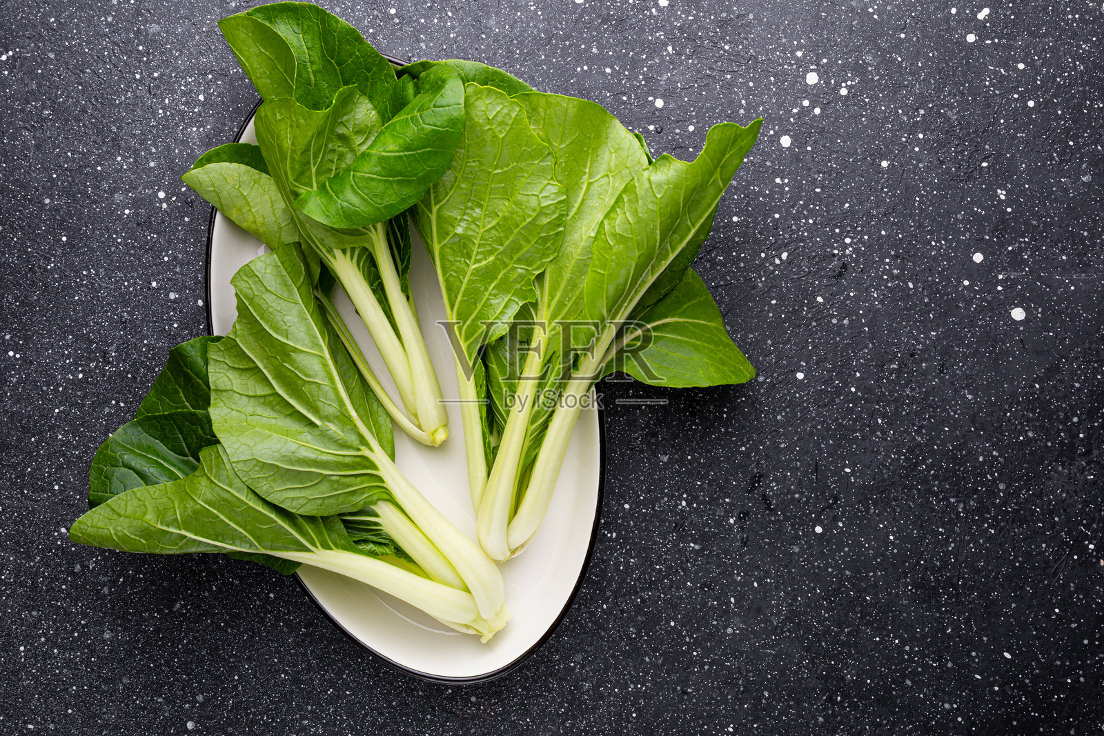 生Pak Choi或小白菜蔬菜在深色背景上的俯视图，新鲜的亚洲卷心菜照片摄影图片