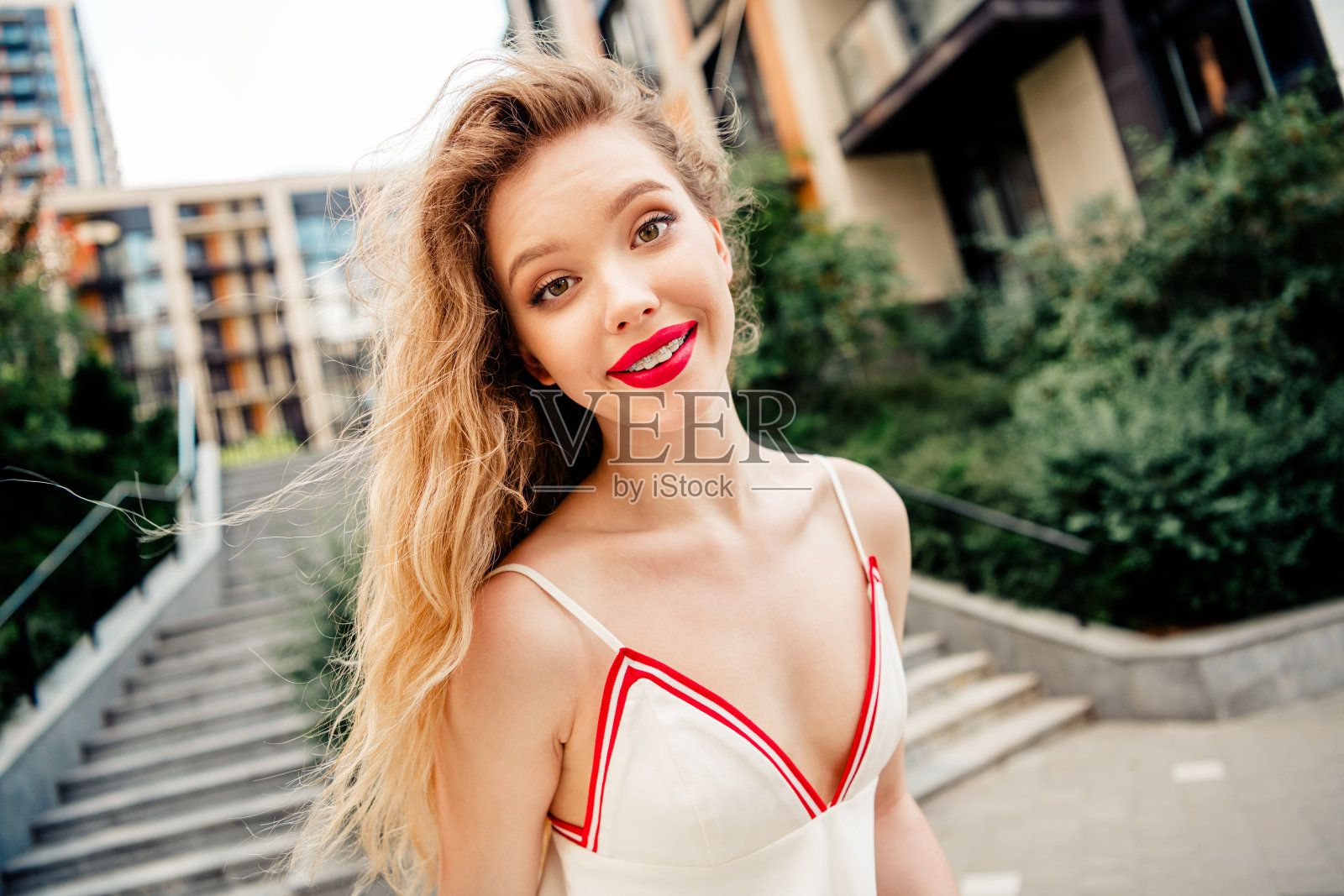 迷人的年轻女性在城市台阶附近穿着时尚，展现出自信与优雅。照片摄影图片