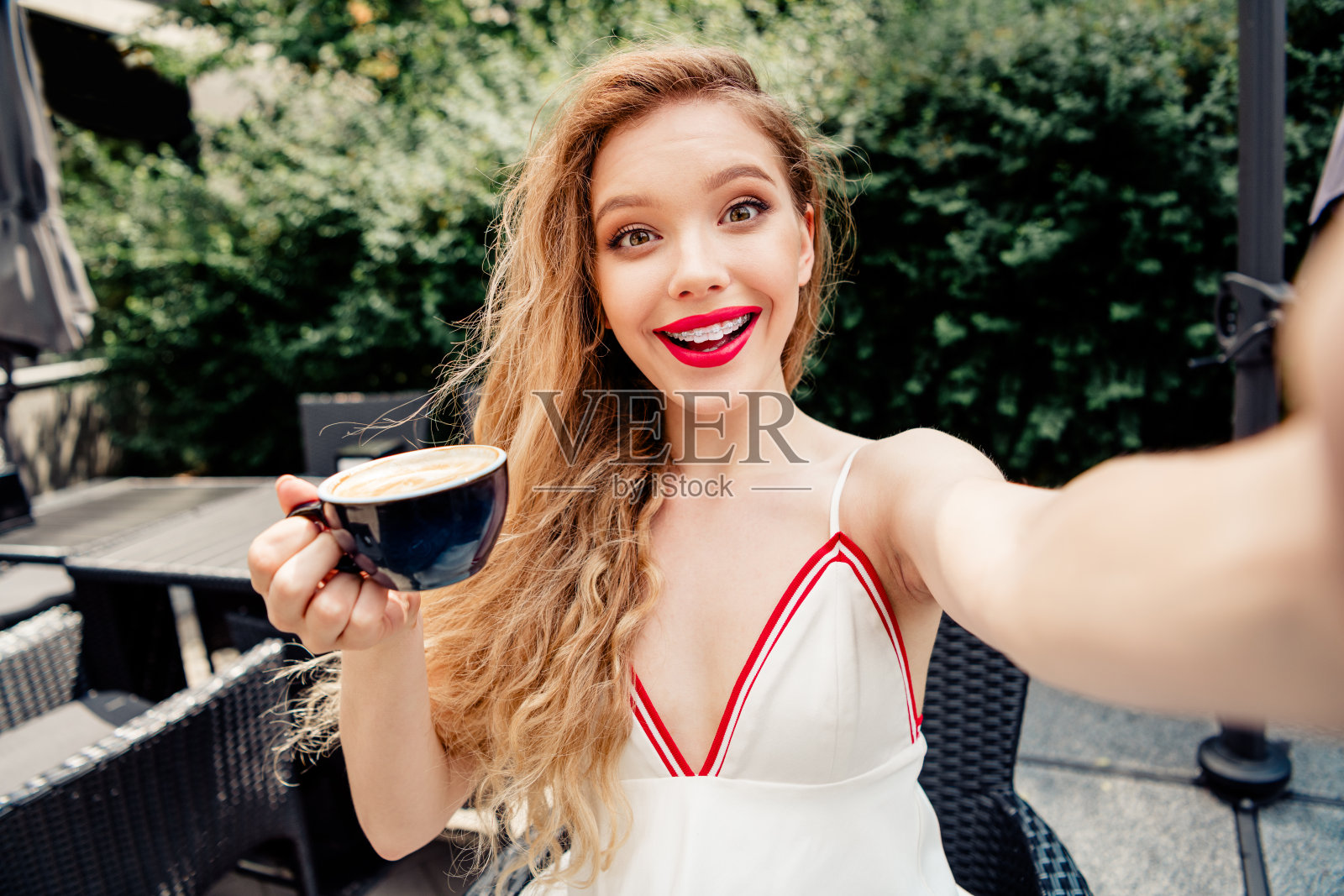 美丽快乐的女性在夏季户外咖啡馆氛围中享受咖啡。照片摄影图片