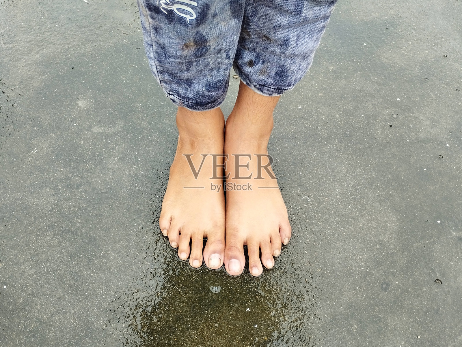 Little Girl Barefoot on Wet Pavement照片摄影图片