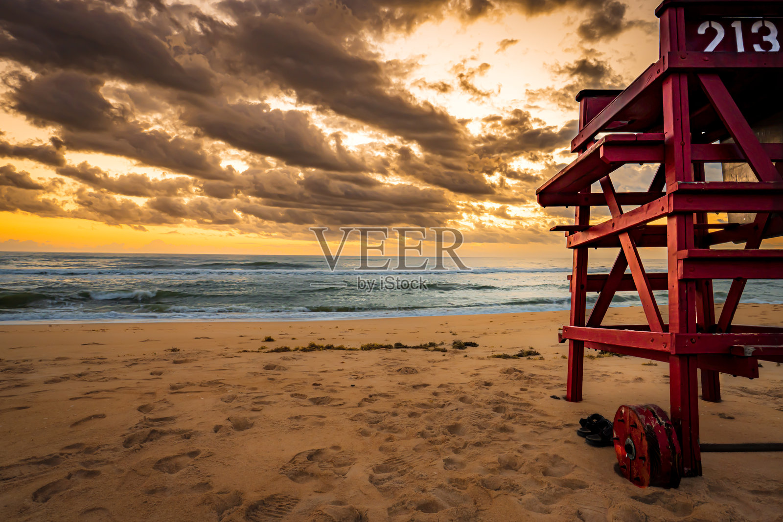 海滩日出在救生员站前照片摄影图片