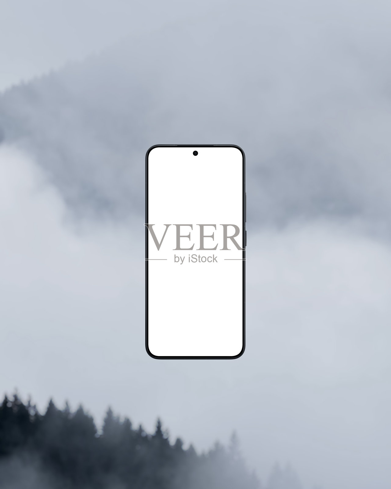 在雾蒙蒙的山背景下的空白白色屏幕智能手机照片摄影图片