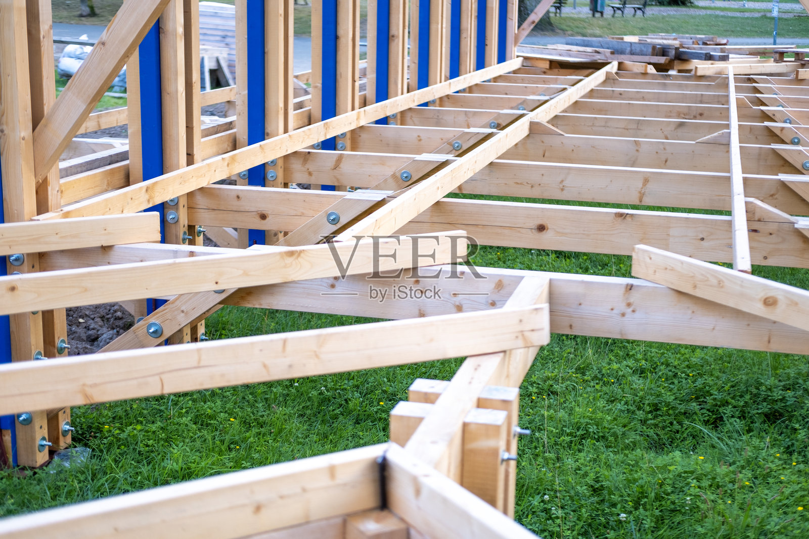 在自然光下，结构木梁形成的商业建筑框架正在施工中，结构元素，原材料照片摄影图片