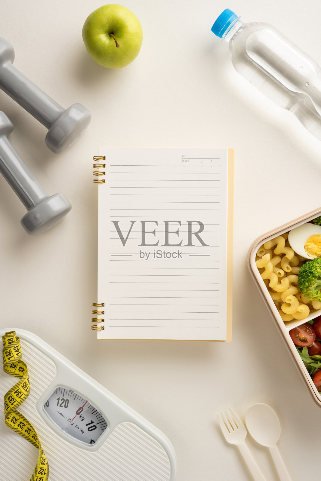 专注于垂直健康与健身，包含食物、哑铃、水、苹果和用于记录进展的日记本照片摄影图片
