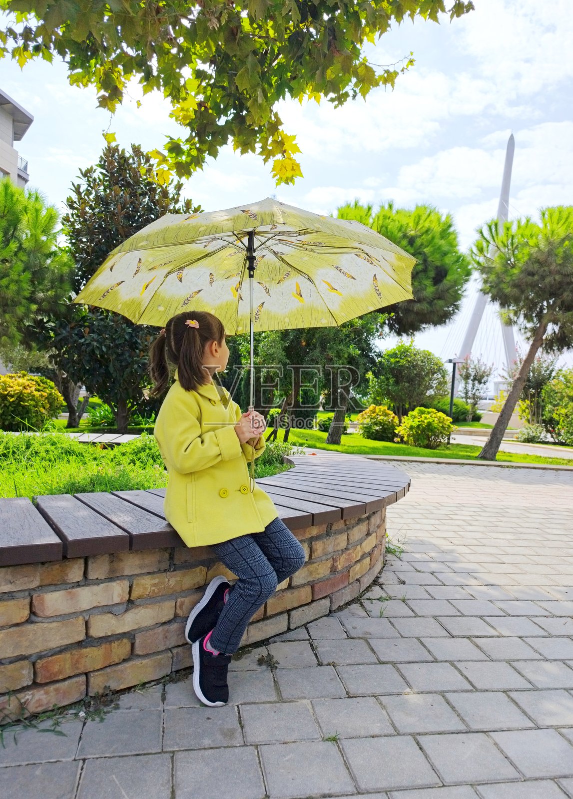 公园里拿着雨伞的小女孩照片摄影图片