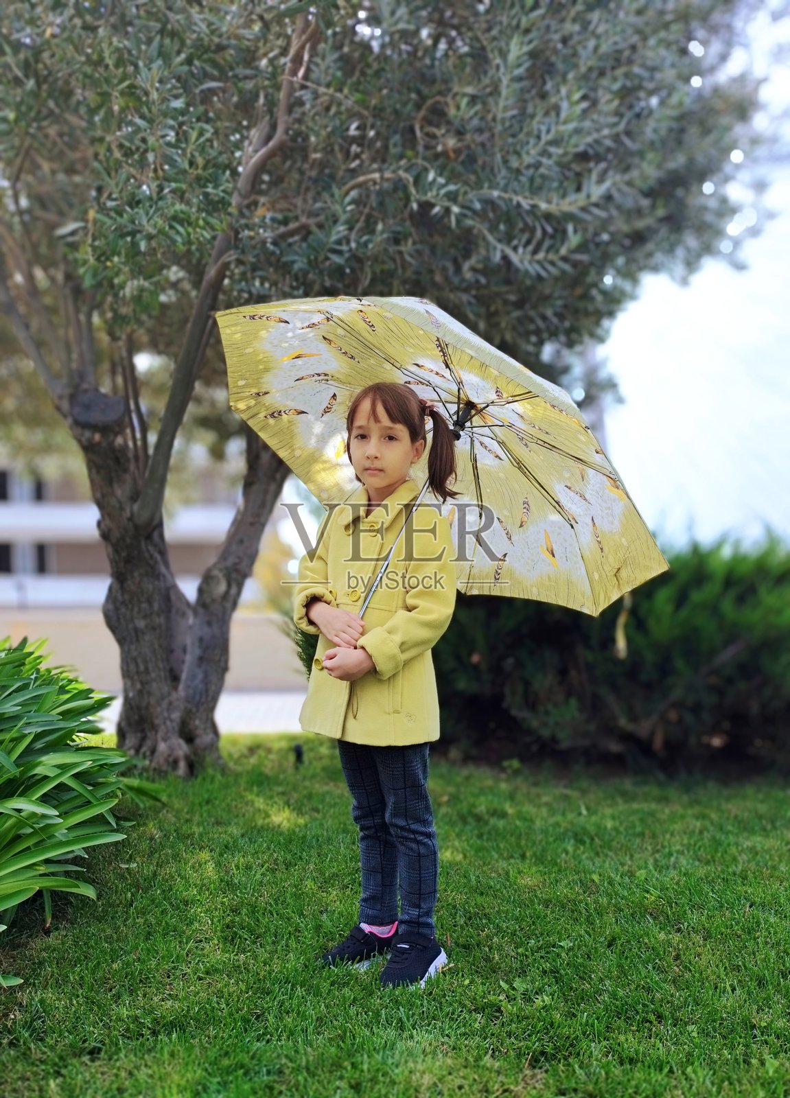 公园里拿着雨伞的小女孩照片摄影图片